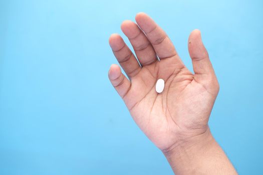 Close up of man hand holding pills with copy space .