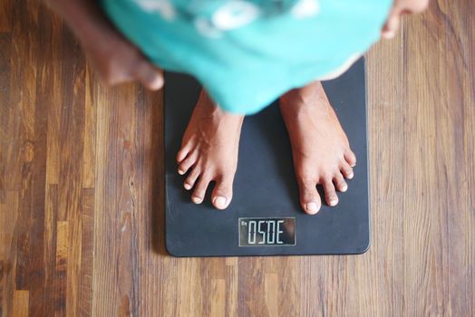 child boy feet on weight scale top view .