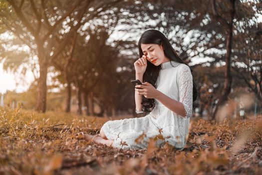 sad woman calling on mobile phone in the park