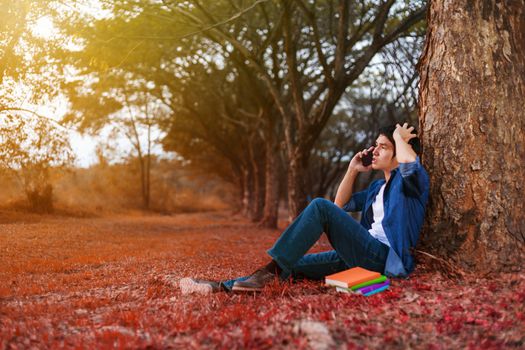 young man in stress situation when talking on mobile phone in the park