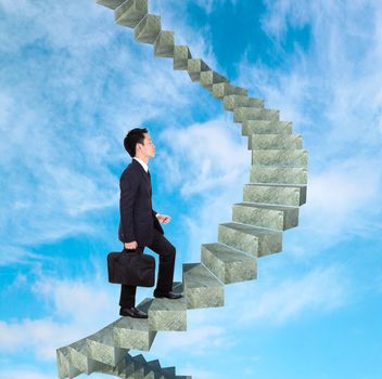 business man going upstairs in a curved staircase to success with blue sky background