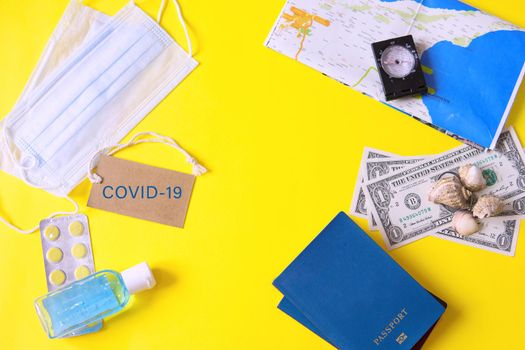 Travel concept with tablets, sterile mask, antiseptic and road symbols id passport, money, compass, map on yellow background. Stop traveling to dangerous places to prevent coronavirus. Space for text