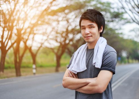 sporty man with arms crossed in the park