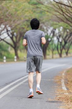 young fitness man running in the park