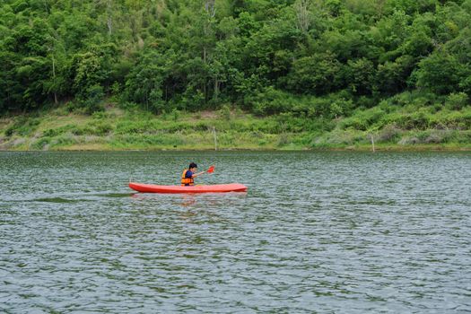 Man paddling in a red kayak boat in Thailand