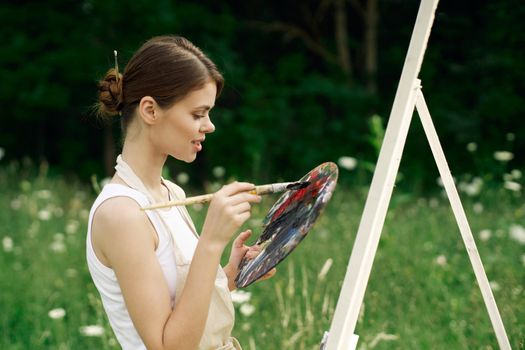 cheerful woman artist painting a picture outdoors creative art. High quality photo