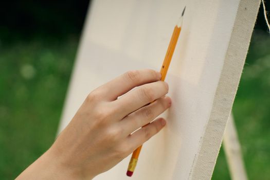 female hand with pencil easel drawing close up. High quality photo