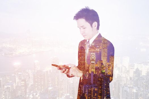 double exposure of business man using smart phone with a city background 