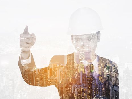 Double exposure of engineer with helmet against a city