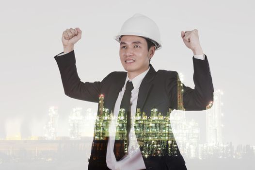 Double exposure of  engineer celebrating with arm raised against the Petrochemical Industrial plant