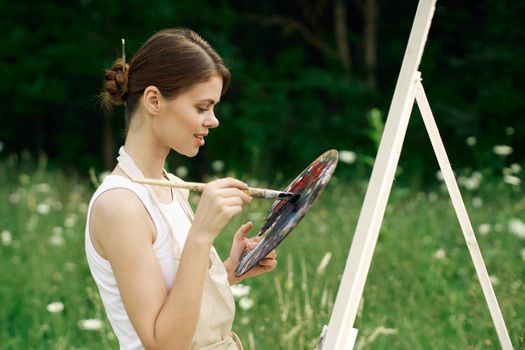 cheerful woman artist painting a picture outdoors creative art. High quality photo