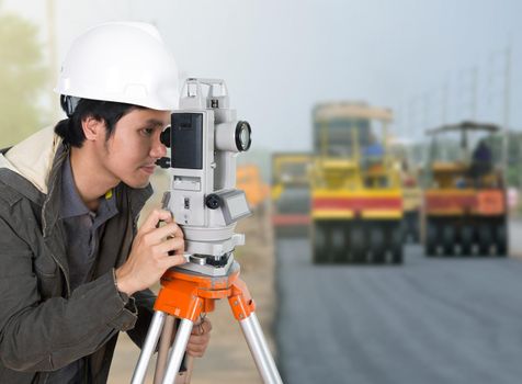 engineer working with survey equipment theodolite with road under construction background