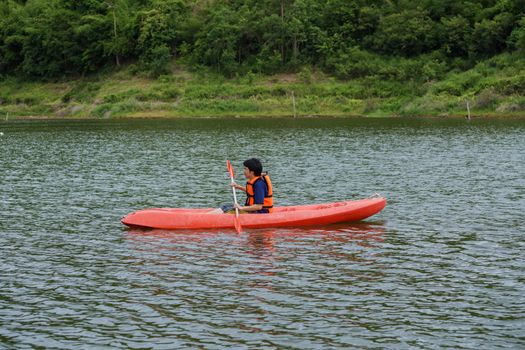 Man paddling in a red kayak boat in Thailand