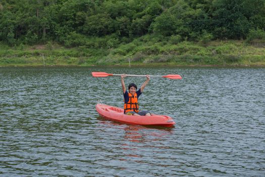 Man paddling in a red kayak boat in Thailand