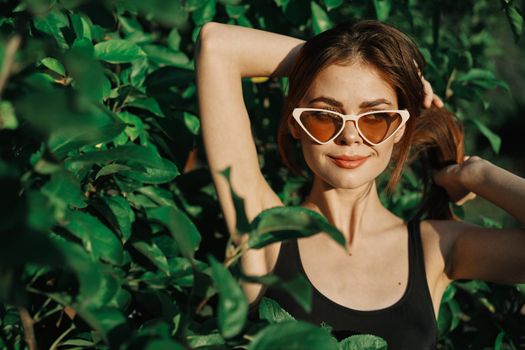 cheerful fashionable woman in sunglasses and green leaves summer luxury. High quality photo