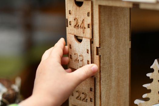 Hand opens wooden advent calendar