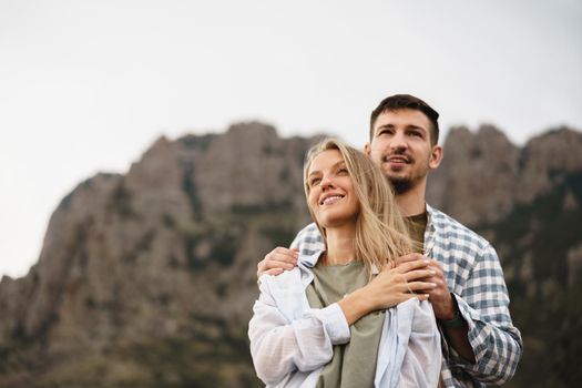 Happy loving couple hiking and hugging in mountains, close up