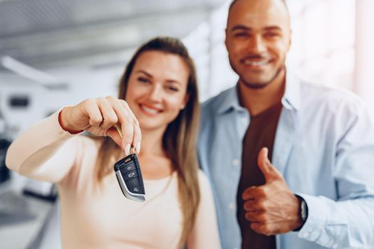 Happy excited couple or family buying a new car and showing keys