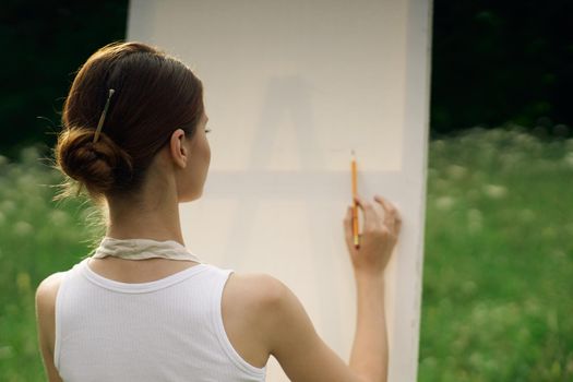 woman artist in aprons in nature draws a picture art. High quality photo