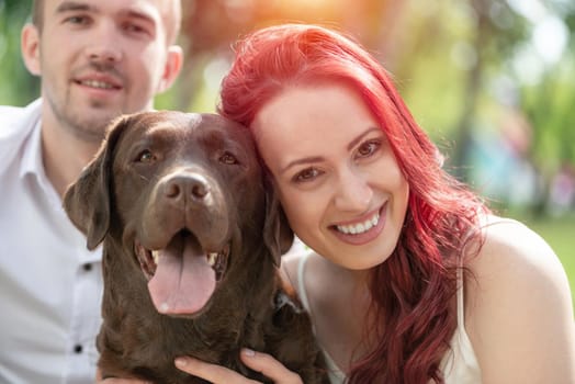 A couple and their dog in the park. Spending time with friends