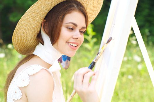 Woman in white dress artist paints on nature palette creative. High quality photo