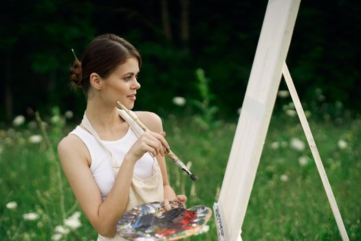 woman outdoors paint a picture landscape hobby creative. High quality photo