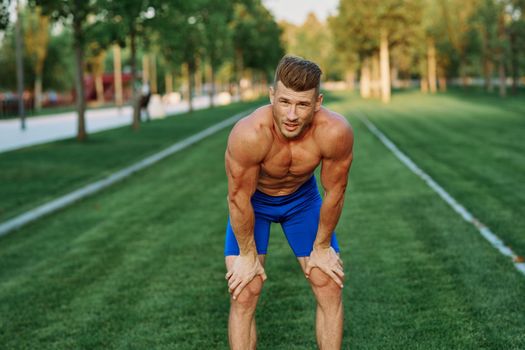 sporty man with pumped up body in park workout exercise. High quality photo