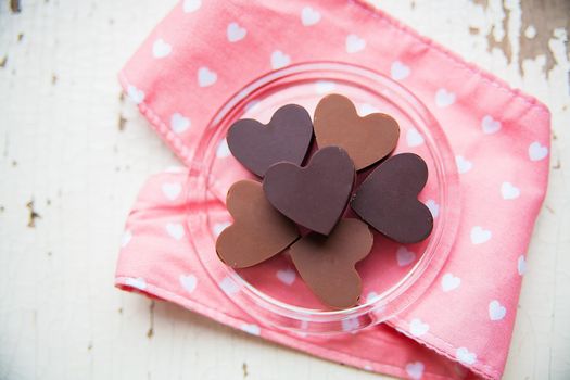 chocolate candy in the shape of a heart on a plate with a pink towel