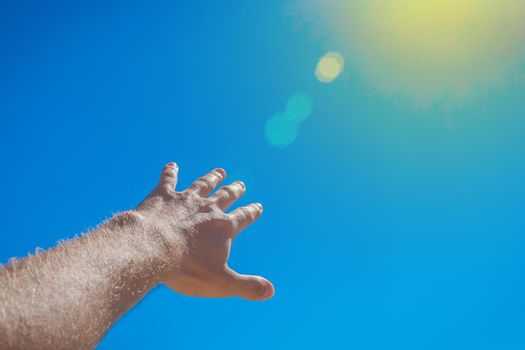 The guy stretched his hand forward towards the blue sky and the sun. The concept of freedom.