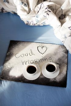 good morning inscription flour on a board with cups of coffee, heart Valentine's day.