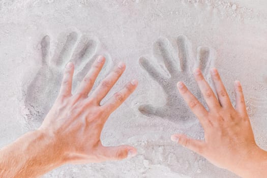 Trail from young male and female hands on white beach sand close-up.