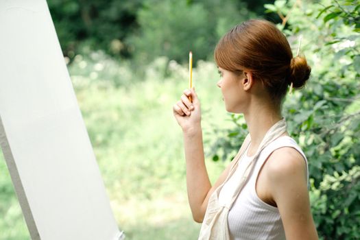 Cheerful woman artist nature easel creative art. High quality photo