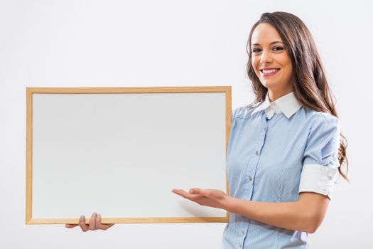 Beautiful businesswoman showing whiteboard on gray background.
