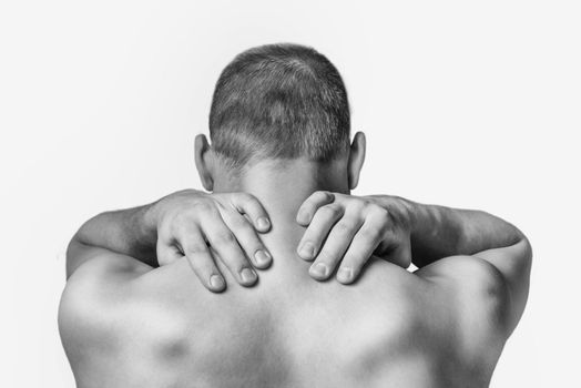 Unrecognizable man touches neck, pain in the neck, rear view. Monochrome image, isolated on a white background