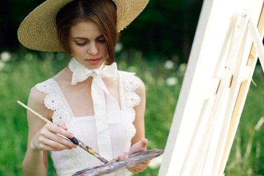 woman artist draws a picture on an easel outdoors. High quality photo