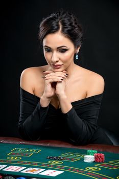 sexy woman with poker cards and chips. Female player in a beautiful black dress