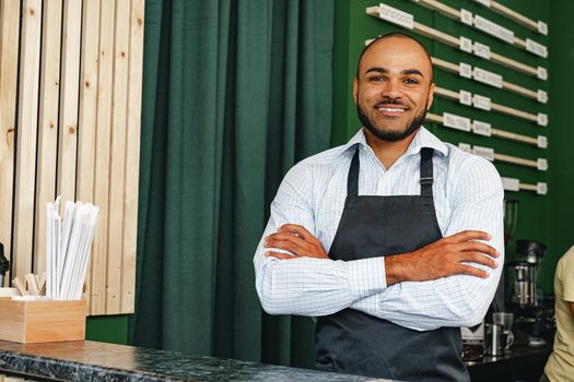Portrait of a mixed race young man barista in coffee shop close up