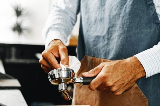 Unrecognizable man barista preparing coffee on professional coffee machine close up