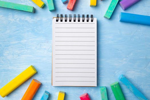 Colorful chalks on blue background with copy space for text. Back to school concept