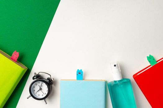 It's time to get back to school. Stationery and alarm clock top view