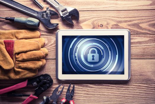 Tablet pc with security concept on screen and industrial tools around