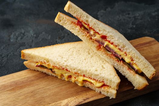 Sandwiches with ham, cheese on dark gray background, close up