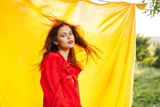 pretty woman in red dress outdoors nature yellow cloth. High quality photo