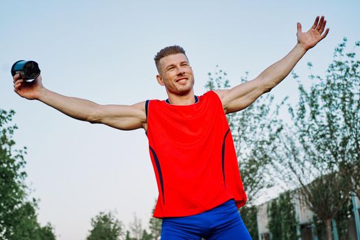 sporty man in the park outdoors glass with drink. High quality photo