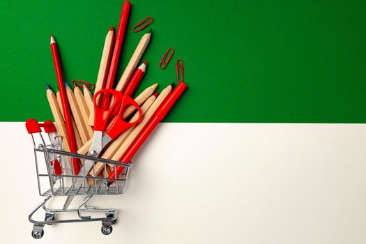 School supplies in a shopping cart top view, copy space
