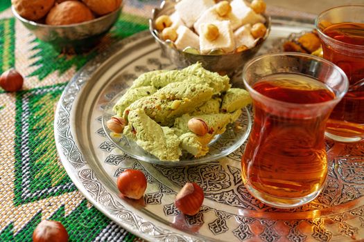 Turkish sweet baklava on metal tray with Turkish tea, close up