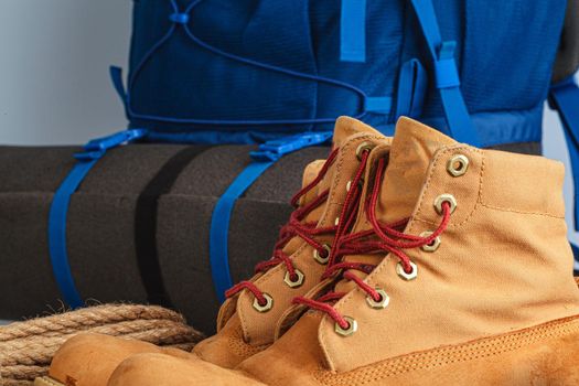 Blue backpack and hiking boots. Mountain gear ready for trip close up