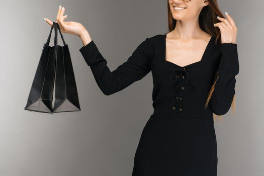 Black friday sale concept. Shopping woman holding bag isolated on background in holiday - Image