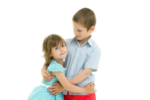 Charming little girl hugging a tall boy with blond hair. A romantic couple is happy with the joint time brought. A happy sister hugs her brother. The concept is a happy childhood. Isolated on white background.