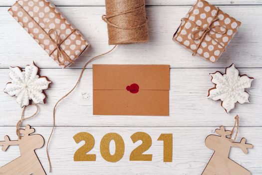 Wrapped Christmas gifts on white wooden board, top view, copy space